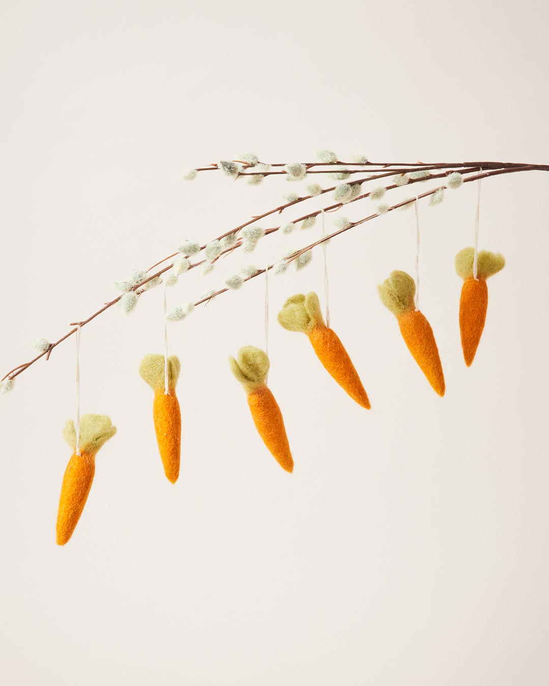 Farmhouse Pottery felted carrot ornaments, set of 6, hanging from a branch